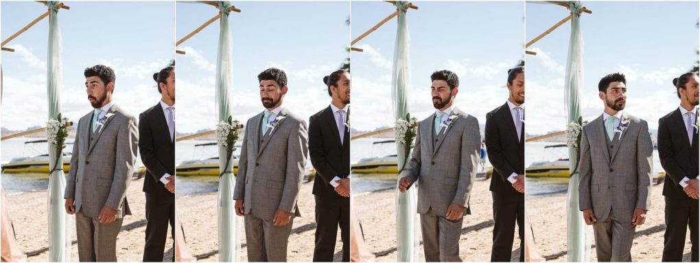 Premier snohomish & seattle wedding photographer | gsquared weddings photography a man in a gray suit stands on a sandy beach by the water during a snohomish wedding ceremony accompanied by another man in a dark suit Yellow boats are visible in the background under the clear seattle sky | serving snohomish seattle                   & beyond