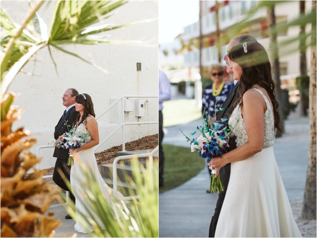 Premier snohomish & seattle wedding photographer | gsquared weddings photography a bride in a white dress holding a bouquet of blue and white flowers walks outdoors with an older man in a suit at a snohomish seattle wedding Palm trees and buildings are visible in the background | serving snohomish seattle                   & beyond