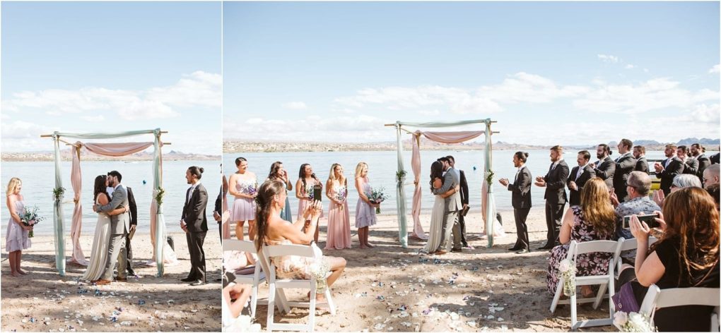 Premier snohomish & seattle wedding photographer | gsquared weddings photography a couple kisses under a decorated arch during their snohomish beach wedding ceremony surrounded by their wedding party and seated guests on a sunny day with blue skies and water in the background | serving snohomish seattle                   & beyond