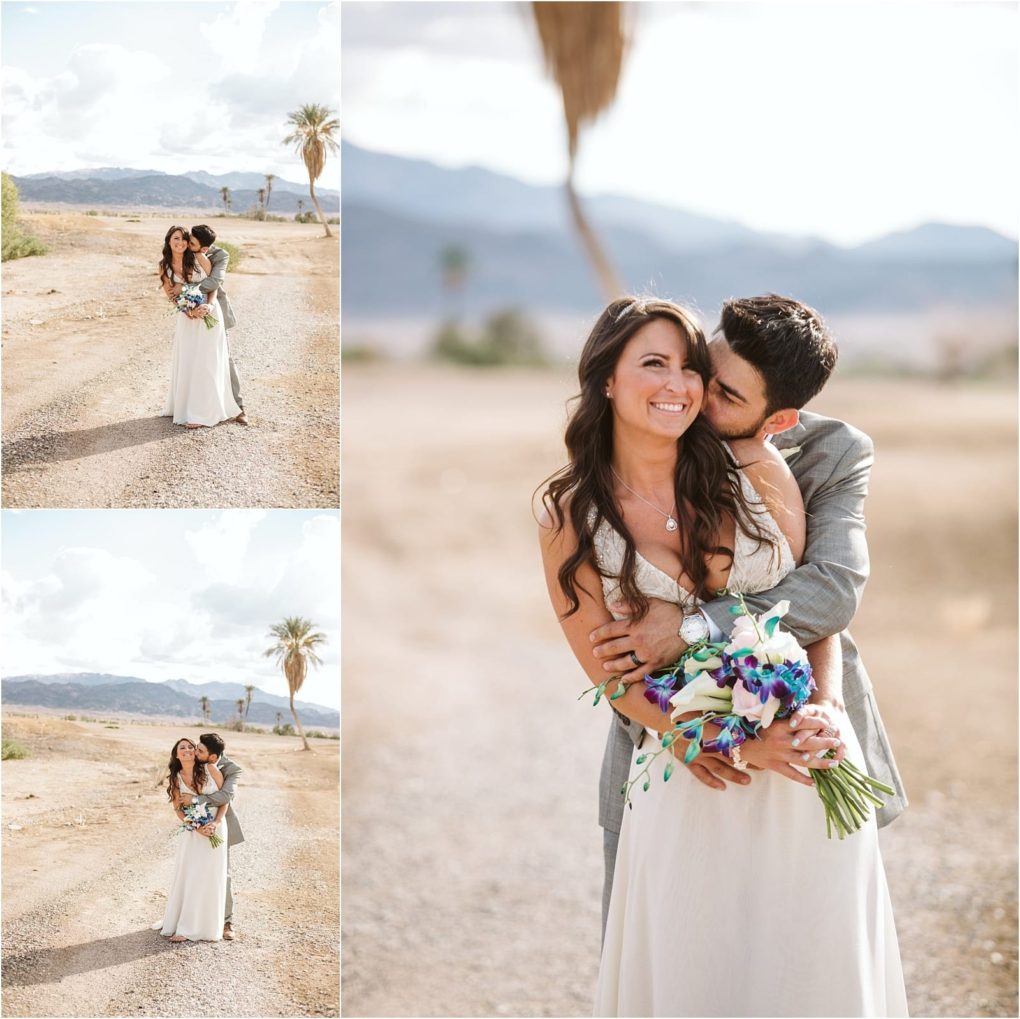 Premier snohomish & seattle wedding photographer | gsquared weddings photography a bride and groom embrace outdoors on a sunny day surrounded by a desert landscape with mountains and a palm treea romantic moment reminiscent of a snohomish seattle wedding as the groom kisses his smiling bride holding a blue and white bouquet | serving snohomish seattle                   & beyond