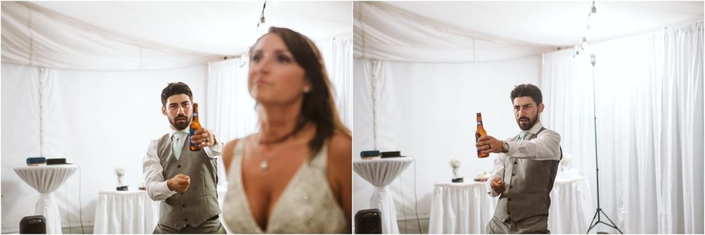 Premier snohomish & seattle wedding photographer | gsquared weddings photography a man in a suit playfully points a beer bottle toward the camera while a woman in a white dress stands in the foreground slightly out of focus at a beautifully decorated snohomish seattle wedding tent | serving snohomish seattle                   & beyond