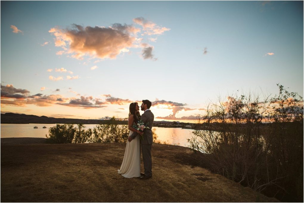 Premier snohomish & seattle wedding photographer | gsquared weddings photography a bride and groom stand close together holding a bouquet and kissing at sunset by a lake near snohomish with soft clouds in the sky and gentle light reflecting on the waterperfect for a seattle wedding engagement | serving snohomish seattle                   & beyond