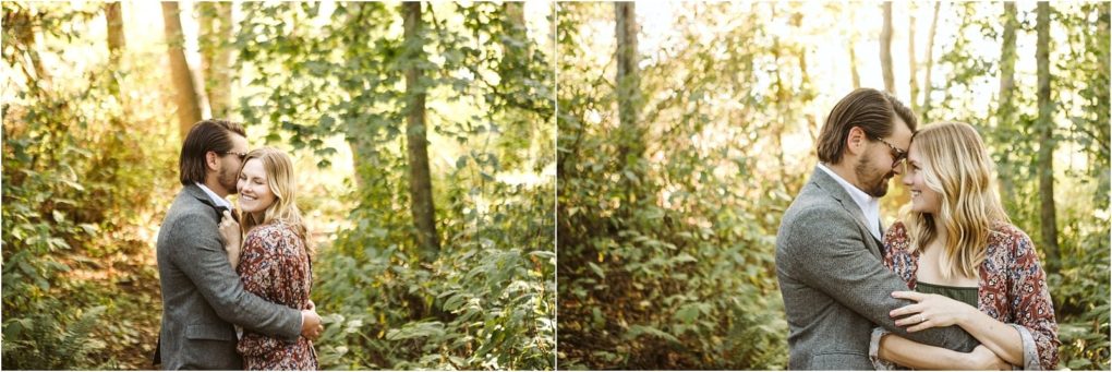 Premier snohomish & seattle wedding photographer | gsquared weddings photography a couple embraces and smiles at each other in a sunlit wooded area during their snohomish seattle wedding engagement The man wears a gray suit and the woman wears a patterned dress surrounded by trees and greenery in a warm romantic atmosphere | serving snohomish seattle                   & beyond