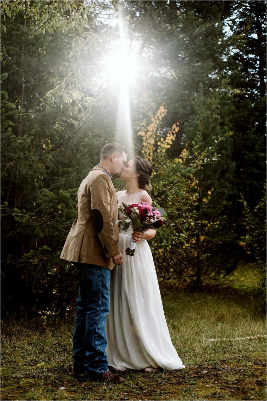 Premier snohomish & seattle wedding photographer | gsquared weddings photography a bride and groom stand closely together in a forest near snohomish sharing a kiss as sunlight beams down The bride holds a bouquet and wears a white dress the groom in a jacket and jeans looks perfect for this seattle wedding moment | serving snohomish seattle                   & beyond