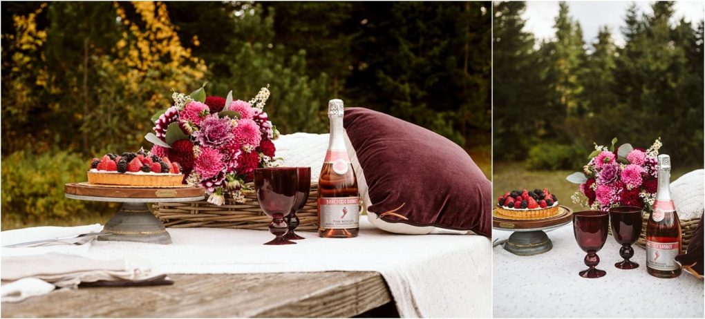 Premier snohomish & seattle wedding photographer | gsquared weddings photography a picnic setup on a wooden table features a berry tart a bottle of rosé wine two purple goblets and pink flowersperfect for a snohomish seattle wedding engagementset outdoors with trees in the background | serving snohomish seattle                   & beyond