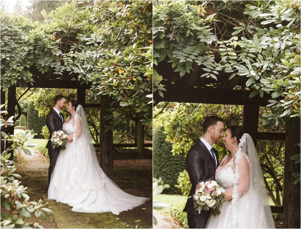 Premier snohomish & seattle wedding photographer | gsquared weddings photography a bride and groom stand close together under leafy greenery at their snohomish seattle wedding gazing at each other and smiling The bride holds a bouquet and wears a long white dress with a veil the groom wears a dark suit | serving snohomish seattle                   & beyond