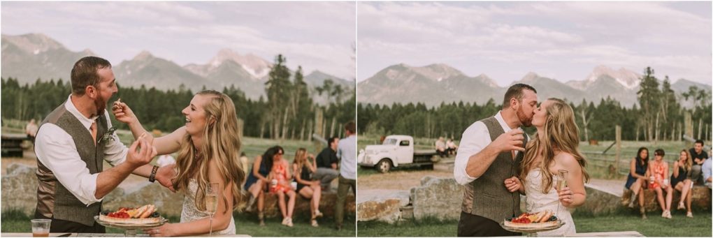 Premier snohomish & seattle wedding photographer | gsquared weddings photography a couple laughs and feeds each other cake then shares a kiss outdoors with mountains in the background at their rustic snohomish wedding while guests sit and watch | serving snohomish seattle                   & beyond