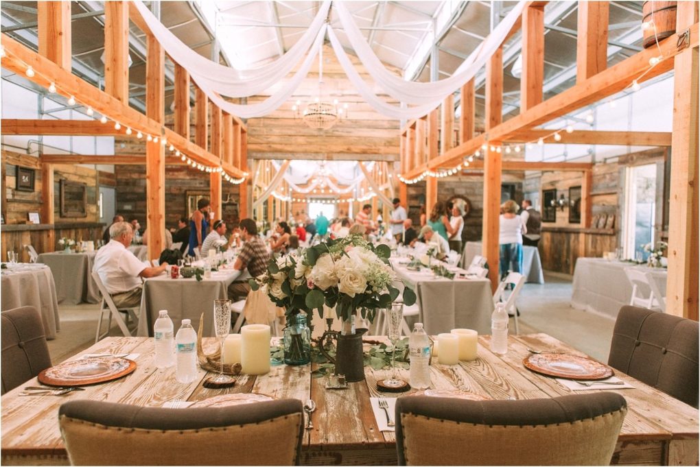 Premier snohomish & seattle wedding photographer | gsquared weddings photography a rustic snohomish wedding reception in a barn features draped white fabric string lights floral centerpieces and guests seated at decorated wooden tables creating a warm festive atmosphere near seattle | serving snohomish seattle                   & beyond