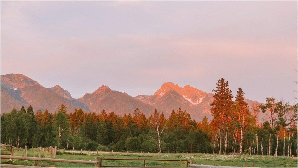 Premier snohomish & seattle wedding photographer | gsquared weddings photography a scenic view of distant mountains at sunset near snohomish with forested trees in the foreground and a wooden fence along green grassperfect for a seattle wedding or engagement as the peaks and trees glow in warm golden light | serving snohomish seattle                   & beyond
