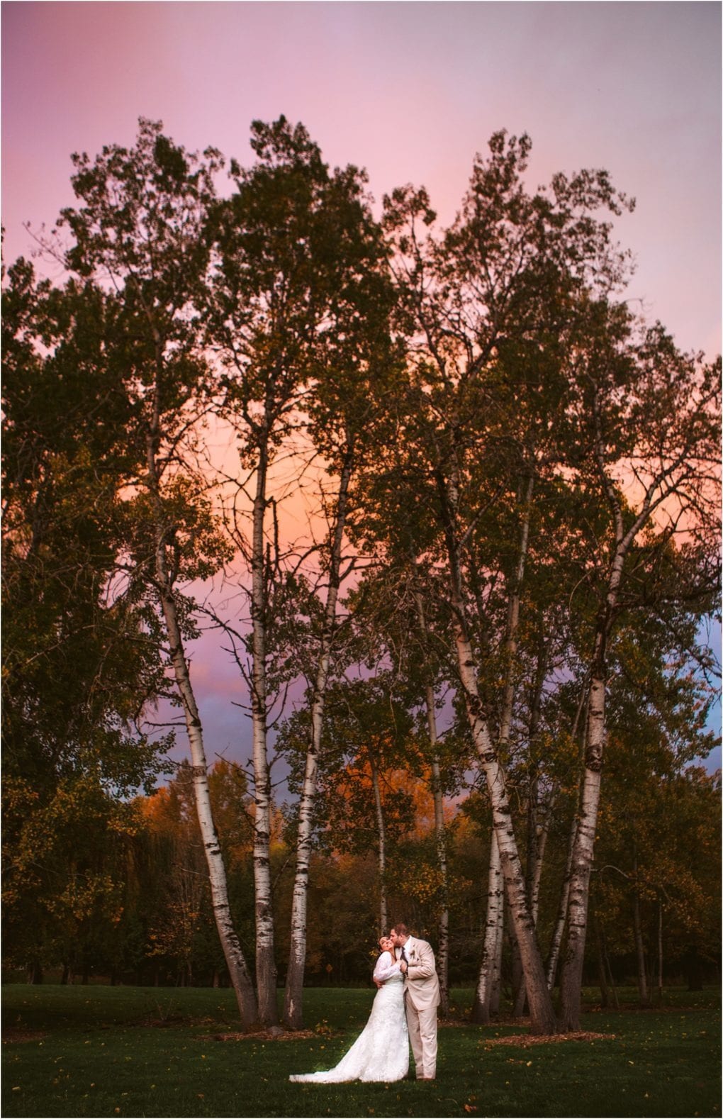 Premier snohomish & seattle wedding photographer | gsquared weddings photography a bride and groom stand close together in front of tall trees at sunset with a dramatic pink and purple sky above and autumn foliage in the backgrounda magical snohomish seattle wedding engagement moment | serving snohomish seattle                   & beyond