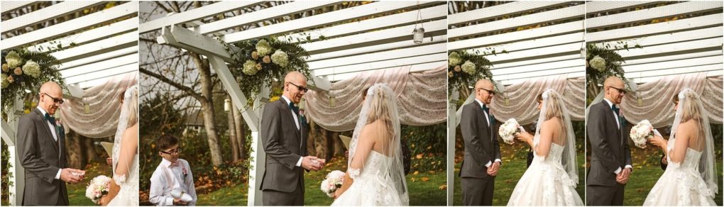 Premier snohomish & seattle wedding photographer | gsquared weddings photography a bride and groom exchange vows outdoors under a white pergola decorated with flowers and draped fabric at a romantic snohomish wedding while a young officiant stands nearby The couple faces each other holding hands with bouquets | serving snohomish seattle                   & beyond