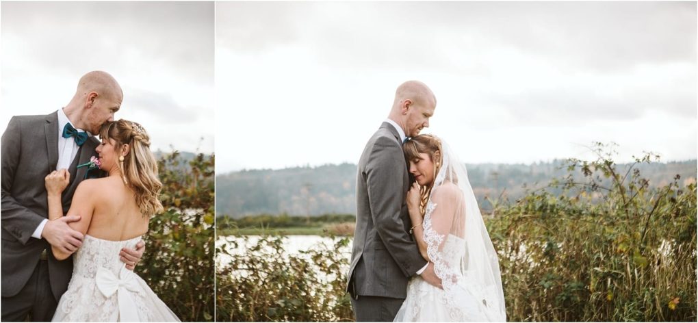 Premier snohomish & seattle wedding photographer | gsquared weddings photography a bride and groom embrace outdoors by a lake and greenery under a cloudy sky during their snohomish seattle wedding The bride wears a white dress and veil the groom a gray suit with teal bow tiethey gaze lovingly at each other | serving snohomish seattle                   & beyond