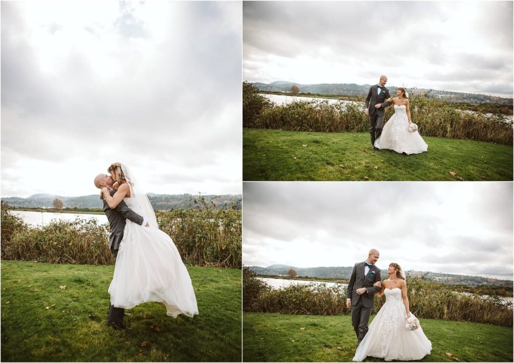 Premier snohomish & seattle wedding photographer | gsquared weddings photography a bride and groom in wedding attire pose outdoors on green grass with a lake and cloudy sky in the background they walk smile and the groom lifts the bride in celebration during their snohomish seattle wedding | serving snohomish seattle                   & beyond