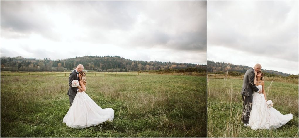 Premier snohomish & seattle wedding photographer | gsquared weddings photography a bride and groom embrace in a grassy field under a cloudy sky with rolling hills and a wooden fence in the background Capturing this snohomish seattle wedding the bride holds a bouquet and wears a white gown while the groom is in a gray suit | serving snohomish seattle                   & beyond