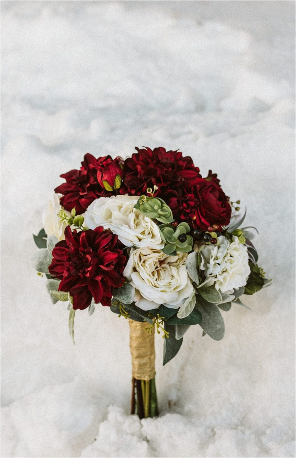 Premier snohomish & seattle wedding photographer | gsquared weddings photography a bridal bouquet with deep red and white flowers green accents and wrapped stems set against a snowy backgroundperfect for a romantic snohomish seattle wedding or engagement | serving snohomish seattle                   & beyond