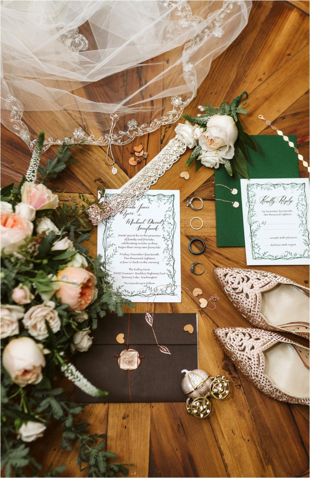 Premier snohomish & seattle wedding photographer | gsquared weddings photography wedding flat lay for a snohomish seattle wedding featuring blush flowers green invitations gold and black rings champagne lace shoes a brown envelope with wax seal garter jewelry and white veil on a wooden floor | serving snohomish seattle                   & beyond