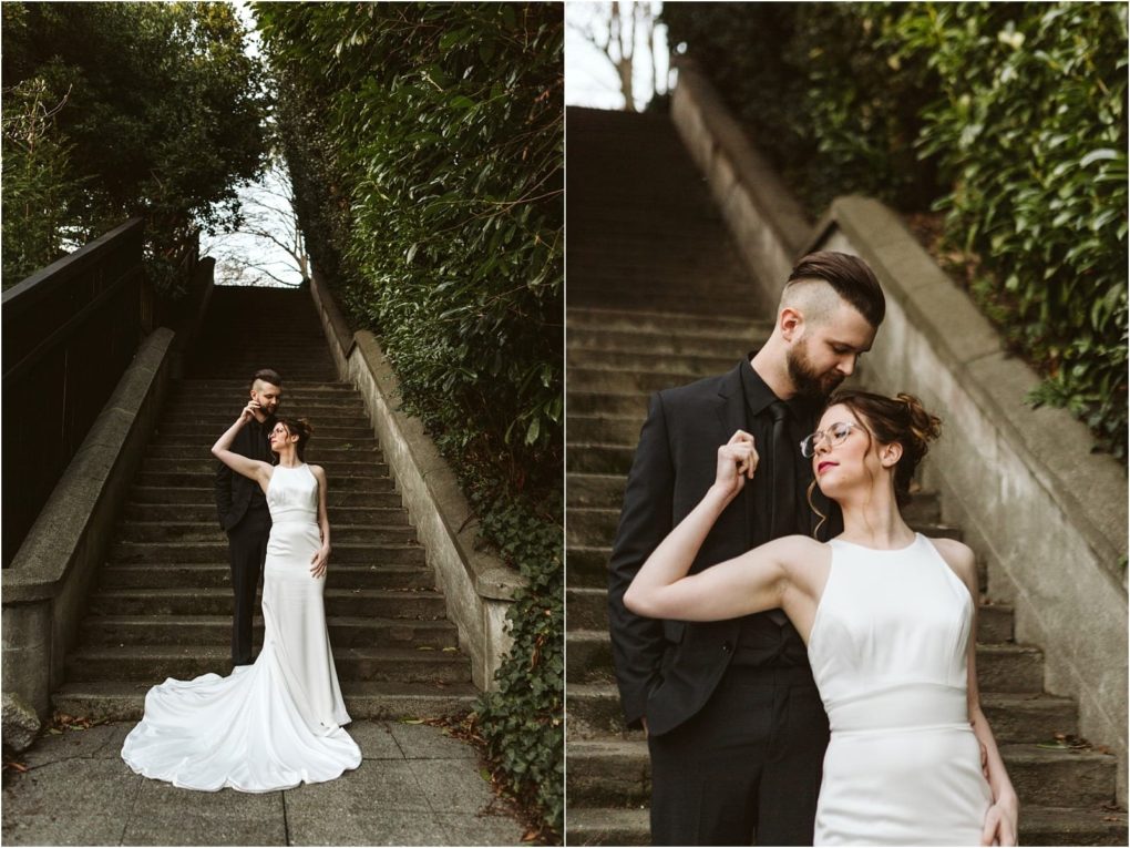 Premier snohomish & seattle wedding photographer | gsquared weddings photography a couple poses on an outdoor stone staircase surrounded by greenery during their snohomish engagement The woman wears a white sleeveless gown the man a black suitthey stand closely appearing affectionate and stylish | serving snohomish seattle                   & beyond