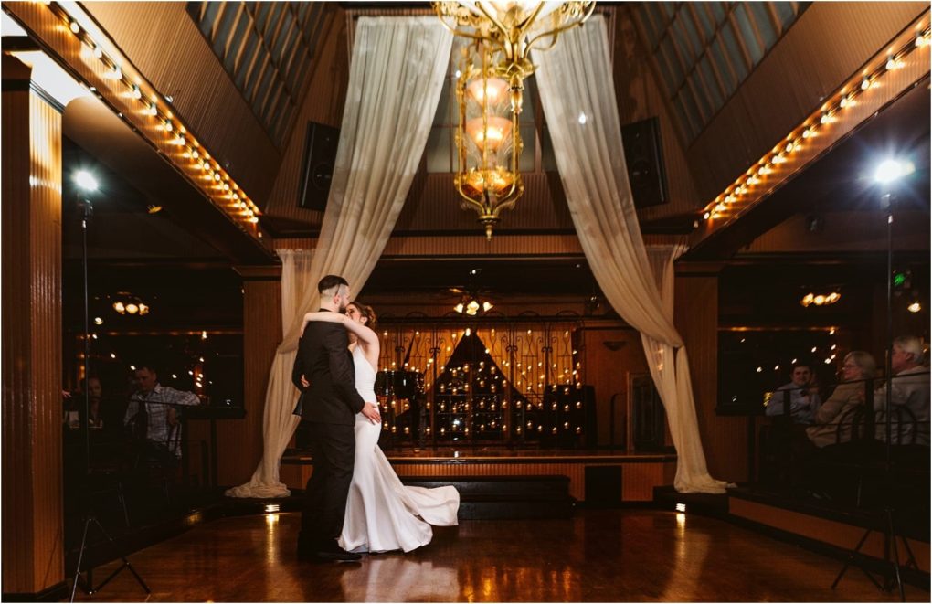 Premier snohomish & seattle wedding photographer | gsquared weddings photography a bride and groom share their first dance under a gold chandelier in a warmly lit elegant snohomish venue with draped curtains as guests look ona beautiful seattle wedding engagement moment | serving snohomish seattle                   & beyond