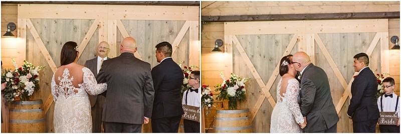 Premier snohomish & seattle wedding photographer | gsquared weddings photography at a rustic indoor snohomish wedding altar a bride in a lace gown stands with her father in the second panel he kisses her forehead before giving her away Two boys holding here comes the bride signs stand nearby at this seattle engagement celebration | serving snohomish seattle                   & beyond