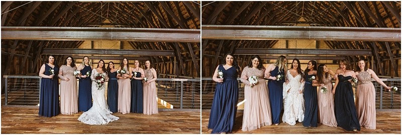 Premier snohomish & seattle wedding photographer | gsquared weddings photography a bride in a white gown poses with six bridesmaids in navy blue and blush dresses inside a rustic snohomish barn Wooden beams and floors set the scene as they hold bouquets and smile for this seattle wedding photo | serving snohomish seattle                   & beyond
