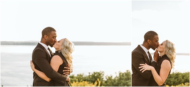 Premier snohomish & seattle wedding photographer | gsquared weddings photography a couple dressed formally embraces and kisses outdoors near a large body of water with trees and hills in the background under soft natural lighta romantic snohomish seattle wedding engagement moment | serving snohomish seattle                   & beyond