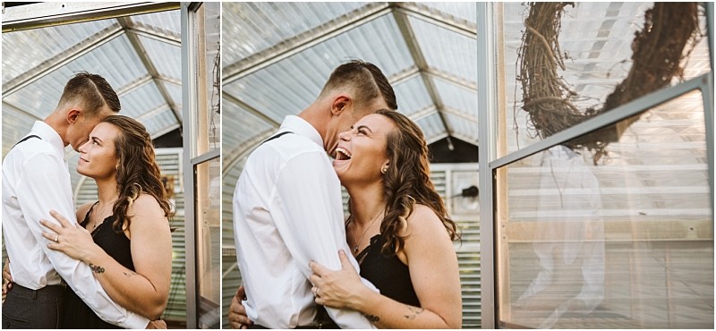 Premier snohomish & seattle wedding photographer | gsquared weddings photography a couple embraces and smiles inside a greenhouse during their snohomish seattle engagement the woman laughing joyfully The man wears a white shirt with suspenders and the woman wears a black dress A rustic wreath hangs on the greenhouse window | serving snohomish seattle                   & beyond