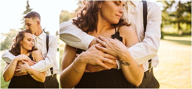Premier snohomish & seattle wedding photographer | gsquared weddings photography a woman in a black dress is embraced from behind by a man in a white shirt with suspenders They stand outside in a sunlit grassy area peacefully enjoying their snohomish seattle wedding engagement moment | serving snohomish seattle                   & beyond