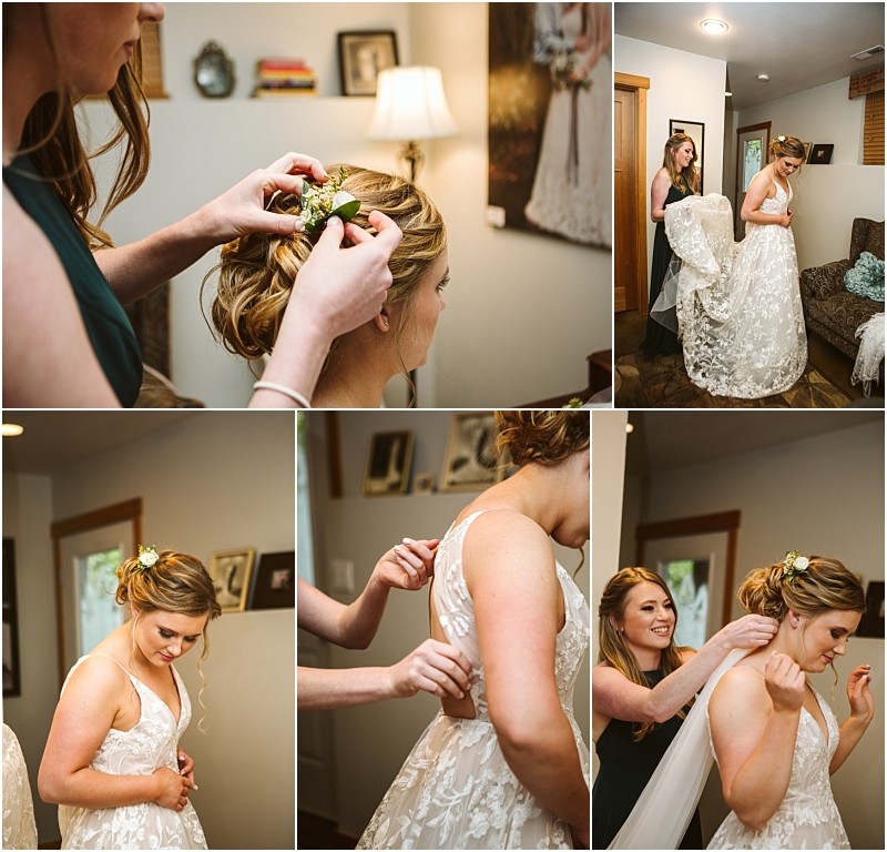 Premier snohomish & seattle wedding photographer | gsquared weddings photography a bride gets ready for her snohomish wedding helped by a bridesmaid adjusting her hair dress and veil She wears a white floral gown with flowers in her hair in a cozy softly lit room with framed photos and a lamp | serving snohomish seattle                   & beyond