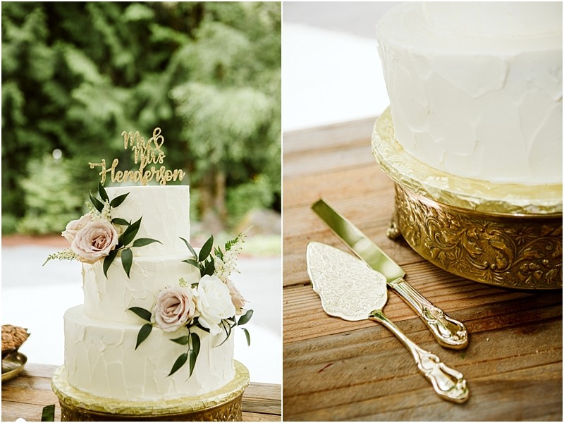 Premier snohomish & seattle wedding photographer | gsquared weddings photography a white two tier wedding cake with pale pink roses and greenery sits on a gold stand beside it are ornate gold cake cutting utensils on a wooden table at a romantic snohomish seattle wedding | serving snohomish seattle                   & beyond