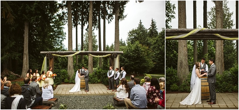 Premier snohomish & seattle wedding photographer | gsquared weddings photography an outdoor snohomish wedding ceremony in a forested area with a bride and groom standing under a wooden arch draped in light fabric surrounded by their wedding party and guests seated on benches | serving snohomish seattle                   & beyond