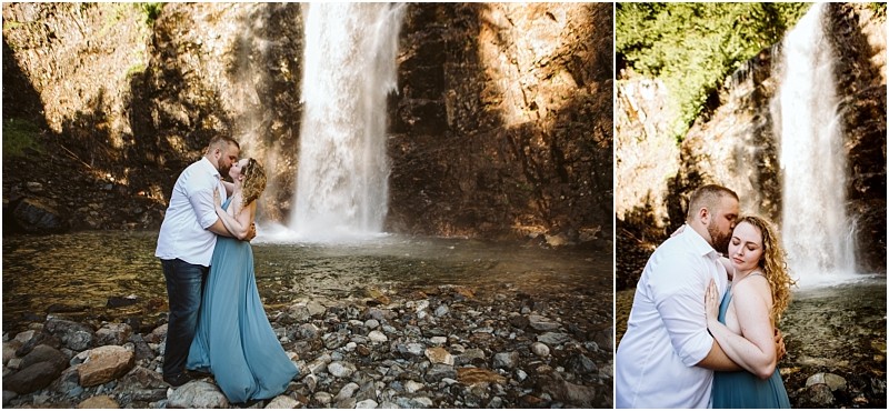 Premier snohomish & seattle wedding photographer | gsquared weddings photography a couple embraces by a rocky riverbank near a large waterfall in snohomish The man wears a white shirt and jeans the woman a flowing blue dress A romantic seattle wedding engagement scene surrounded by nature and sunlight | serving snohomish seattle                   & beyond