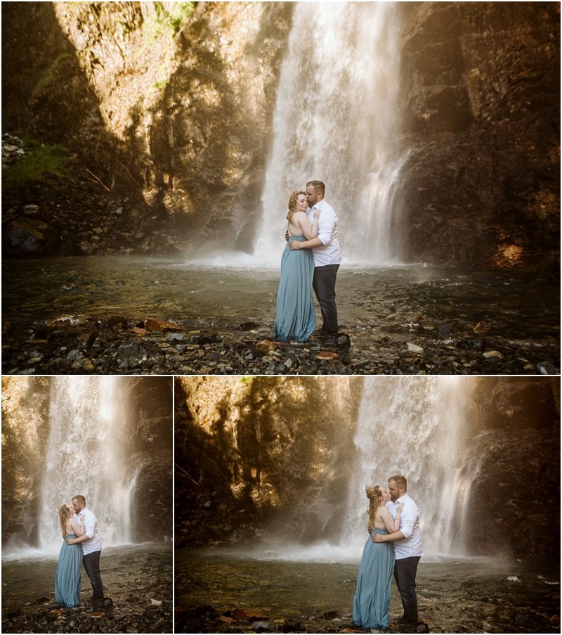 Premier snohomish & seattle wedding photographer | gsquared weddings photography a couple embraces and poses together in front of a tall waterfall near snohomish surrounded by rocks and mist The woman wears a long blue dress the man a white shirtcapturing a romantic seattle wedding engagement moment as sunlight filters through | serving snohomish seattle                   & beyond
