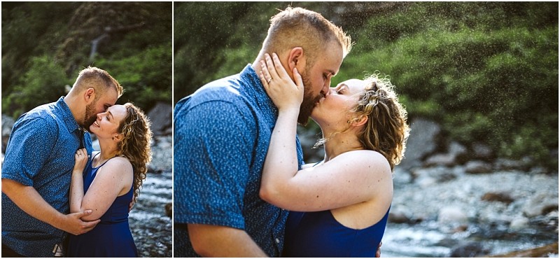 Premier snohomish & seattle wedding photographer | gsquared weddings photography a couple embraces and kisses outdoors near a rocky stream in snohomish surrounded by greenery Both dressed in blue the woman gently holds the mans face as they share a close affectionate seattle wedding engagement moment | serving snohomish seattle                   & beyond