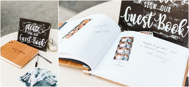 A guest book lies open on a table with handwritten messages and photo booth strips inside A rustic snohomish sign nearby reads please sign our guest book  pens and a closed book are also on the table Snohomish wedding photography