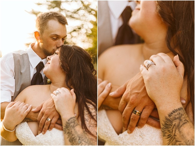 A couple embraces outdoors at sunset in snohomish the man kisses the womans forehead as she smiles They hold hands showing their wedding rings and her tattooed arm capturing a tender and loving moment Snohomish wedding photography