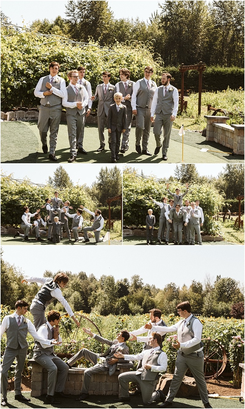 A group of groomsmen in gray suits including a young boy pose and laugh together outdoors in a lush snohomish garden setting under sunny skies Some are standing while others are playfully sitting or lounging Snohomish wedding photography