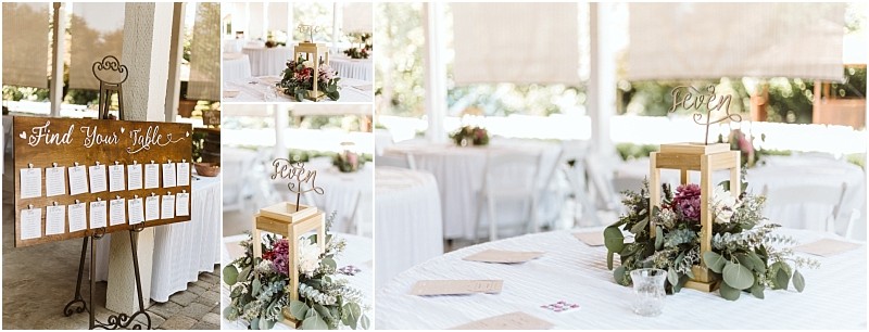 Wedding reception decor in snohomish features a wooden table chart white tables and lantern centerpieces surrounded by greenery and flowers with seven as a table number Natural light enhances the beautiful outdoor setting Snohomish wedding photography