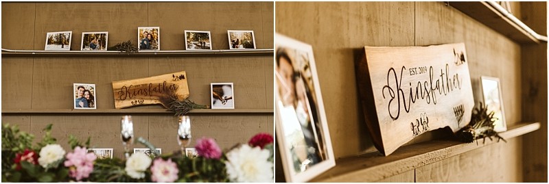 A wooden sign engraved with klingaufamily and est 2017 is displayed on a shelf surrounded by framed family photos and sprigs of greenerycapturing the warm inviting spirit of snohomish Flowers are visible in the foreground Snohomish wedding photography