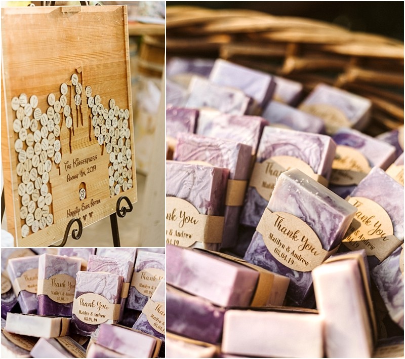 A charming snohomish wedding display with a wooden guestbook sign featuring heart tokens and labeled with names and date beside it baskets of purple marbled soap bars wrapped with thank you tags for guests Snohomish wedding photography