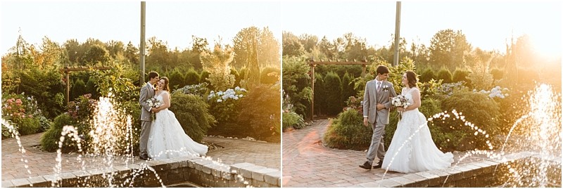 A bride and groom stand together embracing and walking in a snohomish garden at sunset with water fountains in the foreground and lush greenery and flowers in the background Snohomish wedding photography