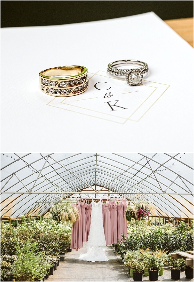 Two wedding rings rest on a card with the initials c & k Below a wedding dress and pink bridesmaid dresses hang in a lush snohomish greenhouse aisle filled with vibrant greenery Snohomish wedding photography