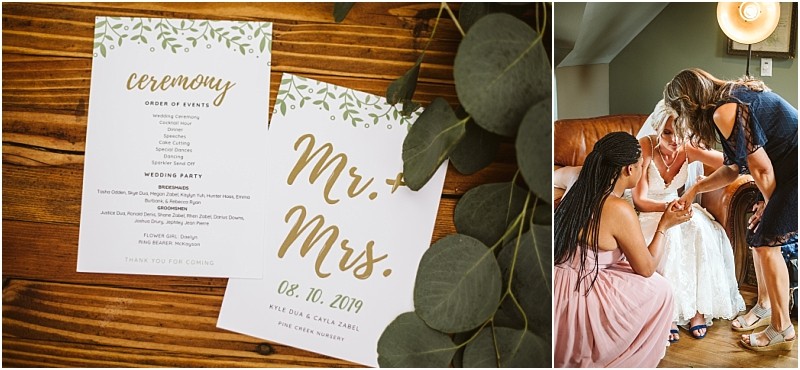 Two wedding programs with green leaf designs and gold text are displayed on a wooden table with eucalyptus in snohomish Nearby women help a bride get ready adjusting her shoe as she sits gracefully in her white dress Snohomish wedding photography