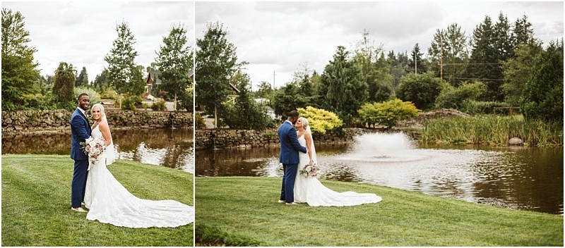 A bride and groom stand together on green grass beside a pond with a fountain in snohomish surrounded by trees and lush landscaping enjoying their outdoor wedding day Snohomish wedding photography