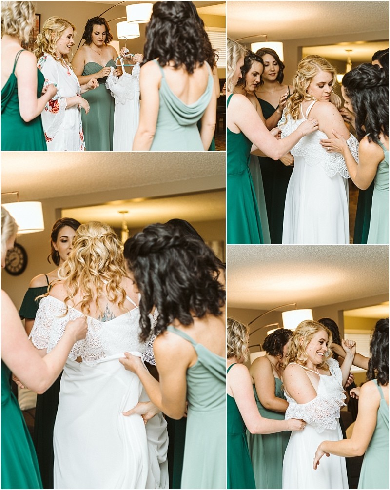 A bride in a white dress is helped by bridesmaids in green dresses as she gets ready in a sunlit snohomish room They adjust her gown and smile together capturing candid joyful moments before the wedding Snohomish wedding photography