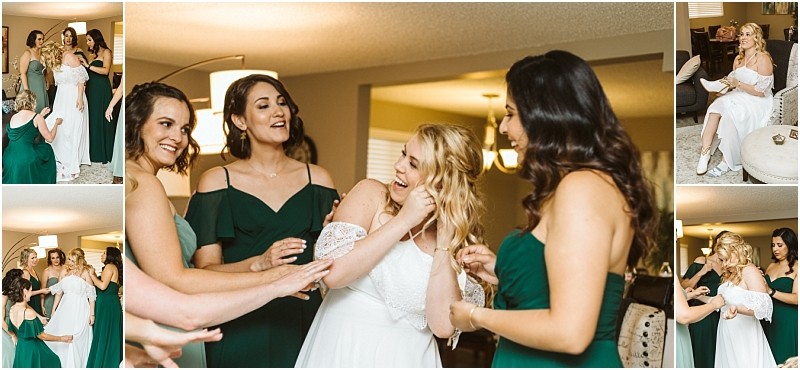 A bride in a white dress smiles and laughs with her bridesmaids who are wearing green dresses as they get ready together in a warmly lit snohomish living room Snohomish wedding photography
