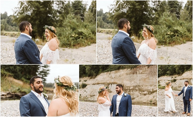 A couple dressed in wedding attire stand outdoors by a rocky snohomish riverside facing each other holding hands smiling and walking together The bride wears a white dress and floral crown the groom is in a blue suit Snohomish wedding photography