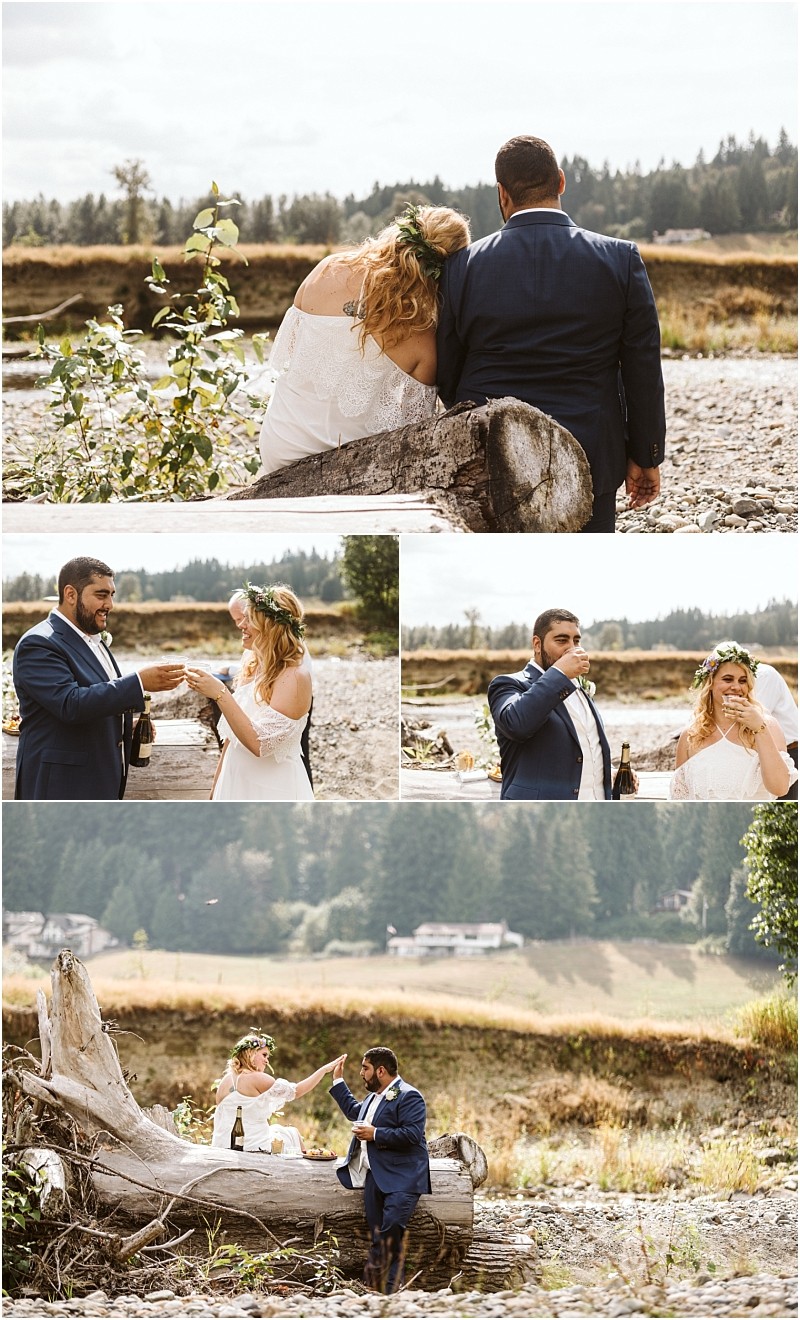 A bride and groom in wedding attire share joyful moments outdoors posing and laughing together beside a large driftwood log in a scenic grassy snohomish landscape with trees in the background Snohomish wedding photography