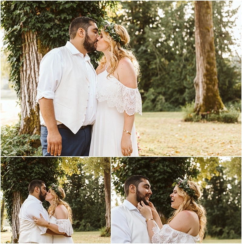 A couple dressed in wedding attire share a kiss and smile at each other outdoors in snohomish surrounded by trees and greenery during a joyful and intimate moment Snohomish wedding photography