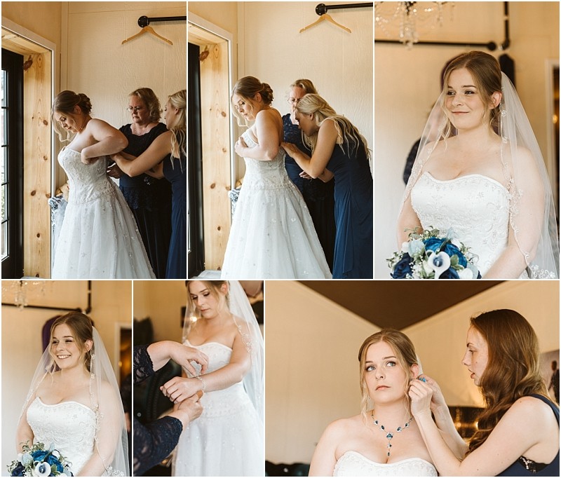 Premier snohomish & seattle wedding photographer | gsquared weddings photography a bride in a white wedding dress gets ready with help from two women before her snohomish seattle wedding They adjust her dress jewelry and veil as she smiles gently in a bright cozy room holding a blue and white bouquet | serving snohomish seattle                   & beyond