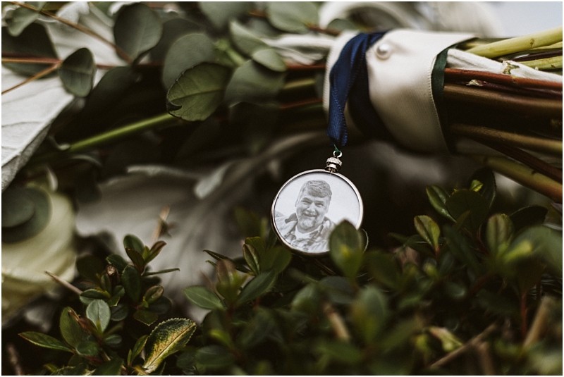 Premier snohomish & seattle wedding photographer | gsquared weddings photography a close up of a bouquet of flowers at a snohomish wedding with a round photo pendant attached showing a smiling man in black and white nestled among green leaves and stems | serving snohomish seattle                   & beyond
